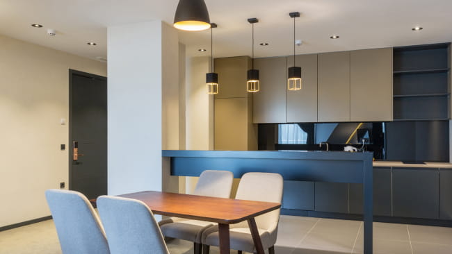 現代的なキッチンにダイニングテーブルと椅子が配置されている画像