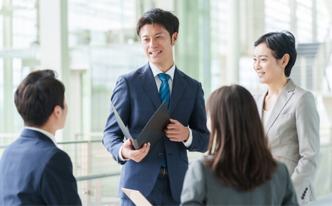 オフィス内でミーティング中のシーンを描いた画像