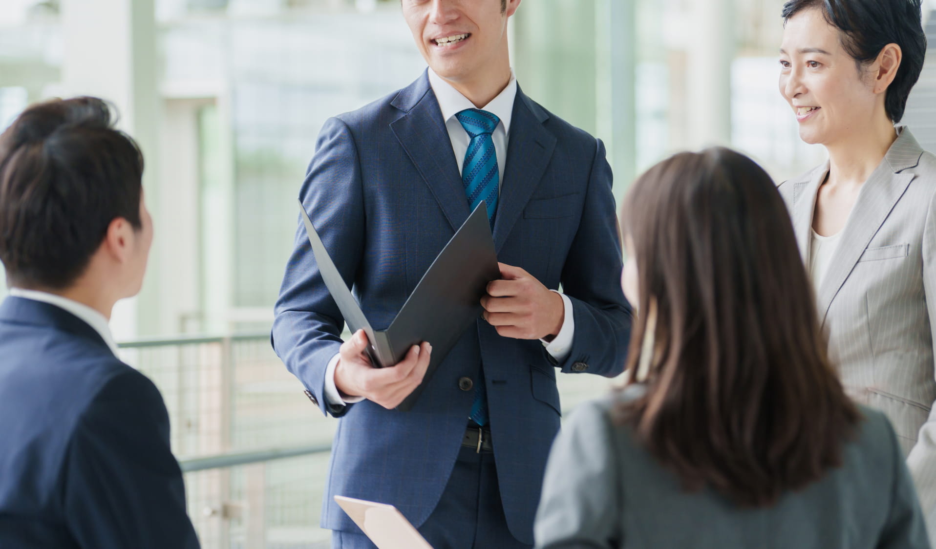 ビジネスの会議中、数名が笑顔でコミュニケーションをとっている様子